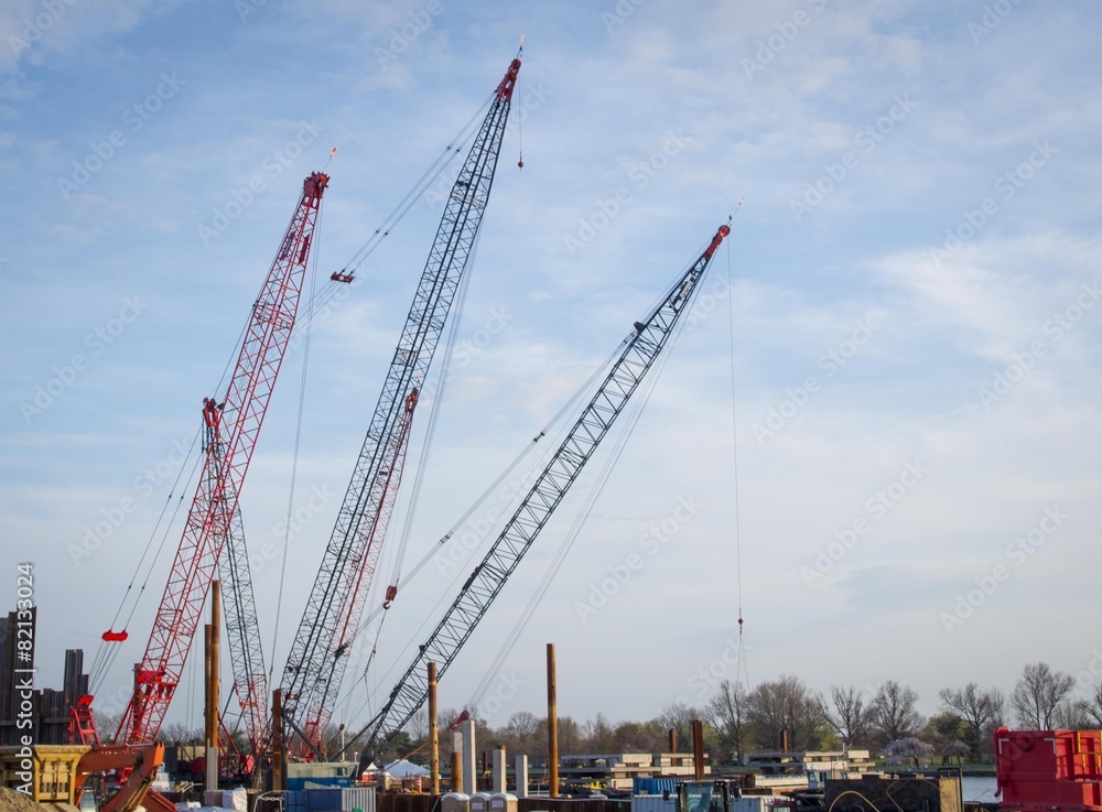 Cranes and Industrial Work Area Against Blue Sky