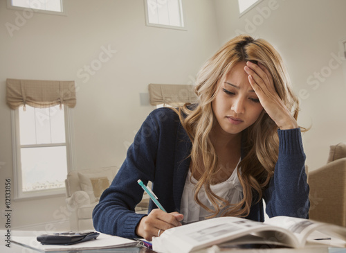 Anxious mixed race woman studying