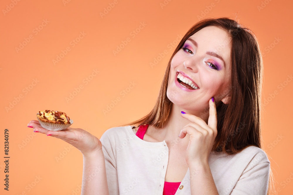 Smiling woman holds cake in hand