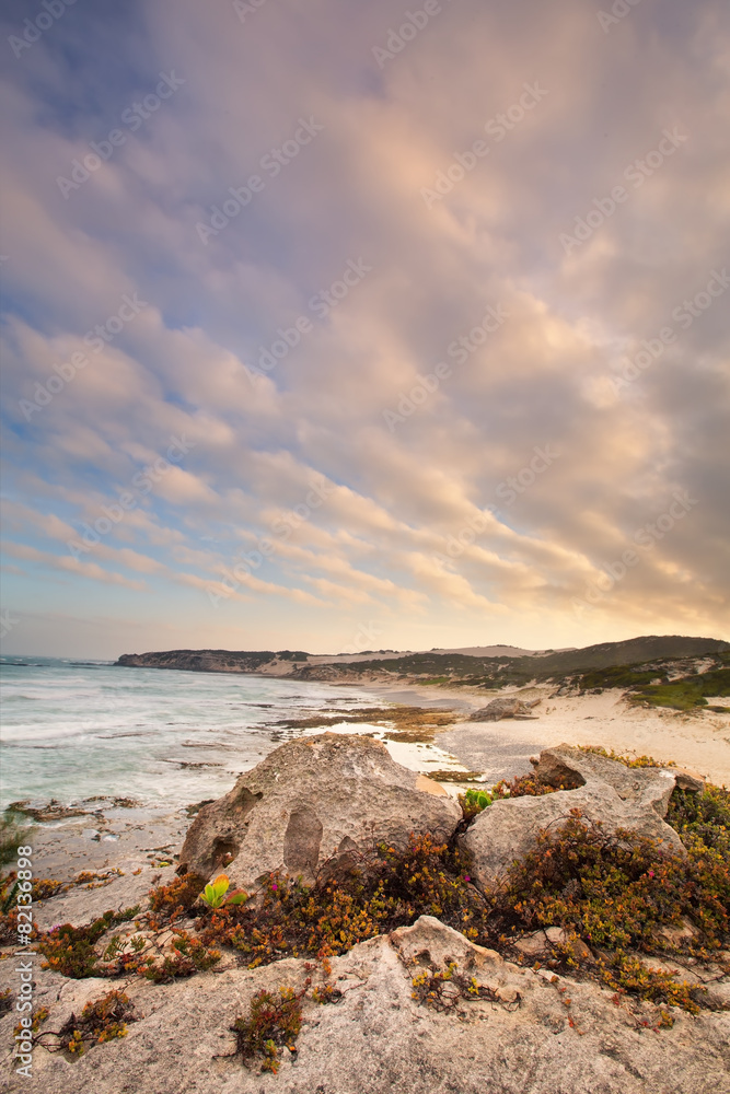 Late evening landscape of ocean over rocky shore heavy clouds bl