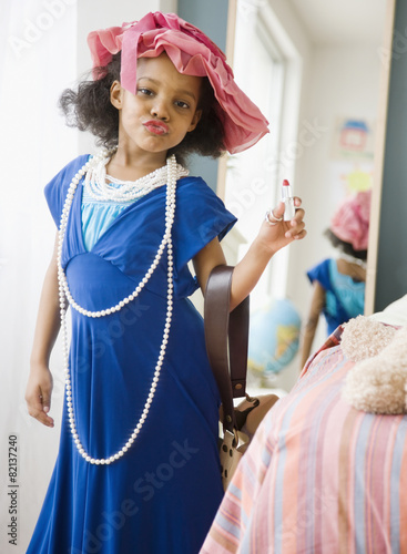 Mixed race girl playing dress-up in mother's clothes