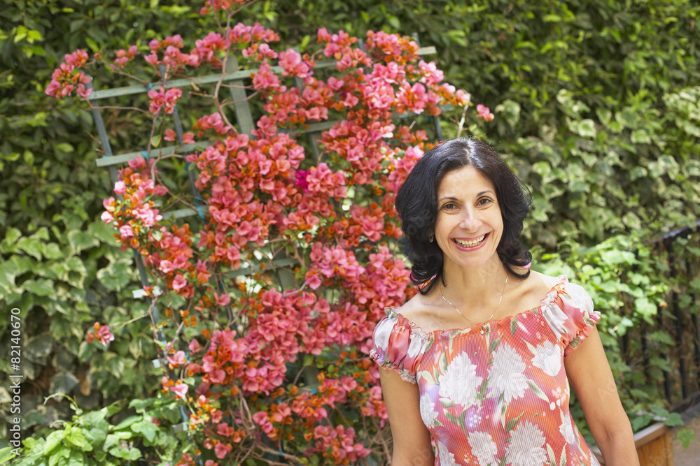 Confident Middle Eastern woman standing in garden Confident Middle Eastern woman standing in garden
