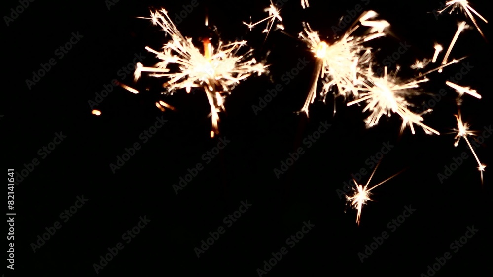 Person`s hand sets fire and holding sparklers on black Person`s hand sets fire and holding sparklers on black