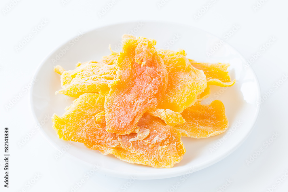 Piece of Dehydrated mango on white ceramic dish Piece of Dehydrated mango on white ceramic dish