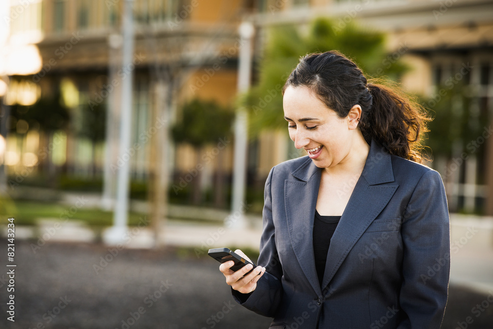 Hispanic businesswoman using cell phone Hispanic businesswoman using cell phone