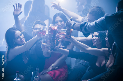Friends toasting each other in nightclub photo