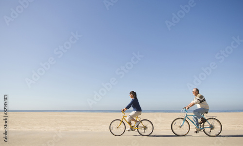 Couple riding bicycles on beach photo