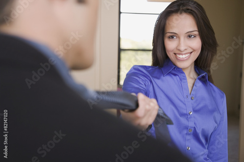 Hispanic woman leading husband into the bedroom