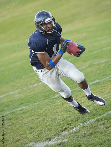 African American football player carrying ball photo