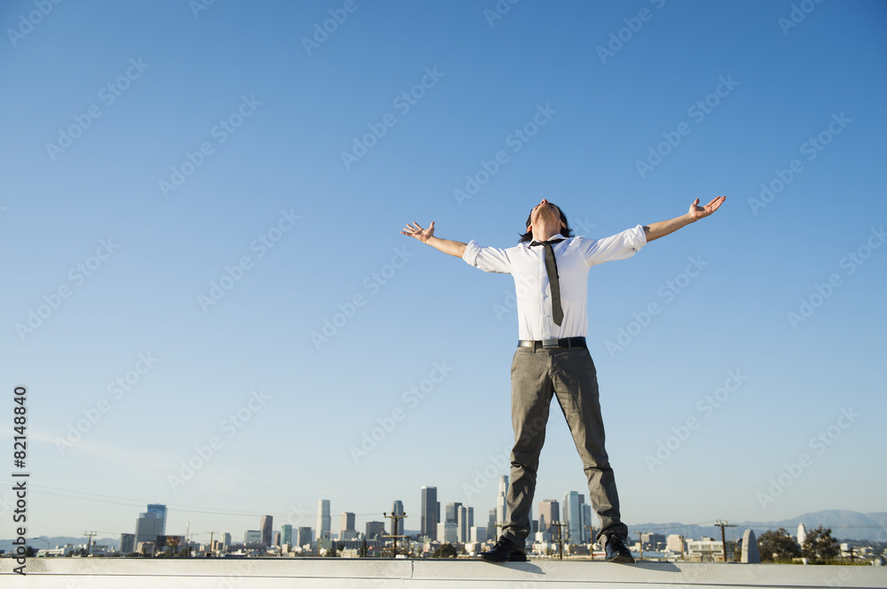 Mixed race businessman standing on urban rooftop Mixed race businessman standing on urban rooftop