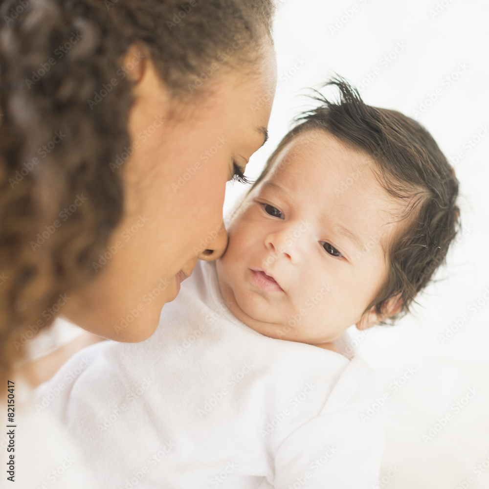 Hispanic mother nuzzling baby's cheek Hispanic mother nuzzling baby's cheek