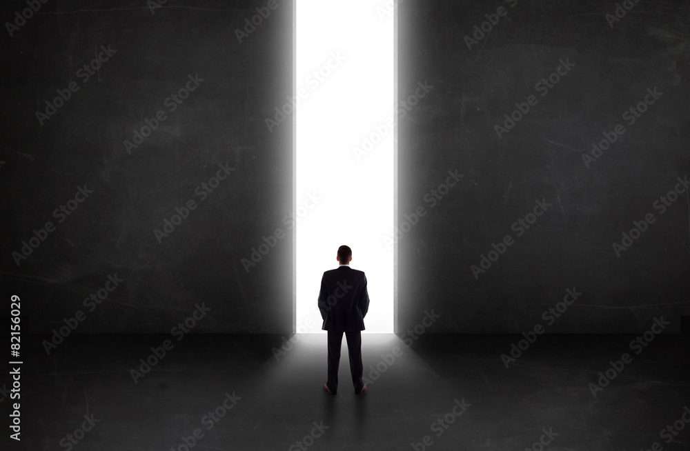 Obraz premium Business person looking at wall with light tunnel opening