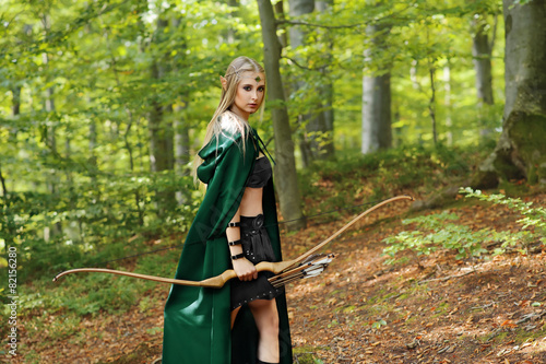 фотографія female elf with a bow in the forest