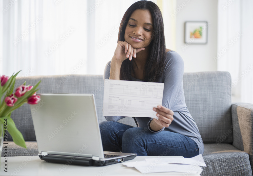 Mixed race woman paying bills with laptop Mixed race woman paying bills with laptop