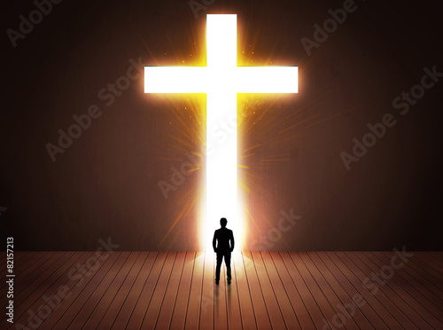 Man looking at bright cross sign photo