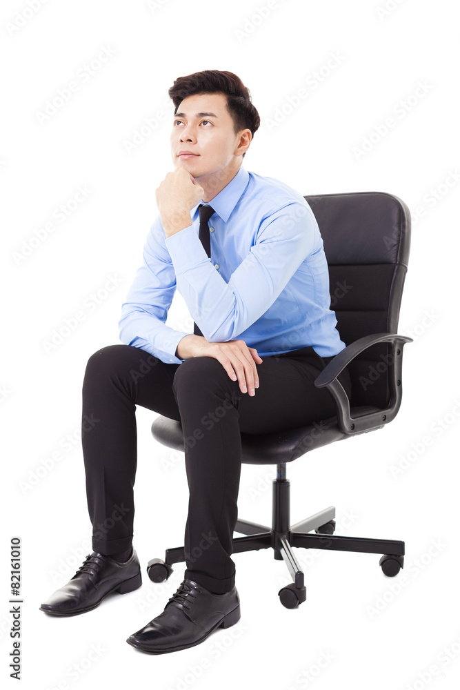 Young businessman sitting in a chair and thinking Young businessman sitting in a chair and thinking