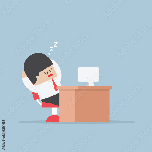 Tired businessman falls asleep at his desk
