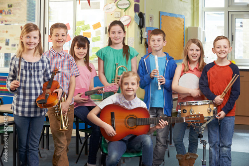 Portrait Of Students Playing In School Orchestra Together photo