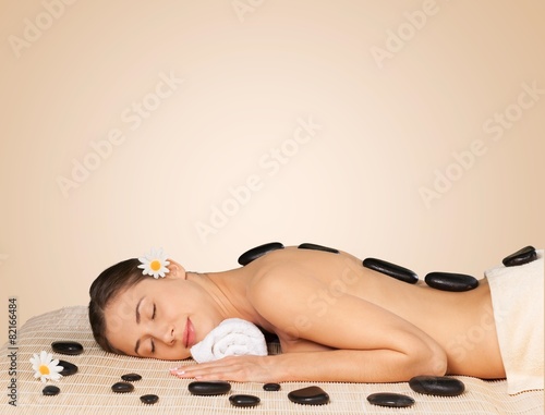 Spa Treatment. Spa salon  woman relaxing on mat with flowers and