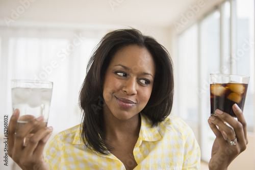 African American woman choosing water or soda