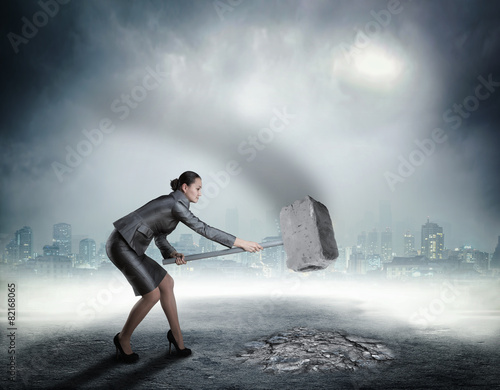 Fotografie Businesswoman with sledgehammer