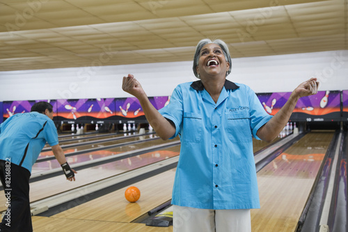 African woman cheering in bowling alley