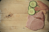Wooden cutting board with ham and vegetable with sapce for text