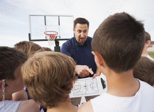 Caucasian coach talking to basketball team