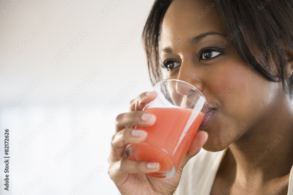 African American woman drinking glass of juice African American woman drinking glass of juice