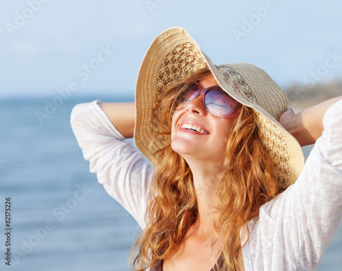 Happy woman relaxing at the beach. Summer vacations concept © olezzo
