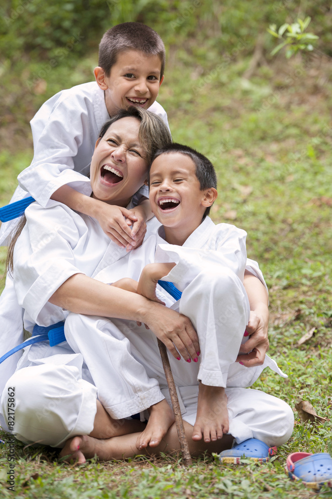 Hispanic family wearing martial arts robes in grass Hispanic family wearing martial arts robes in grass