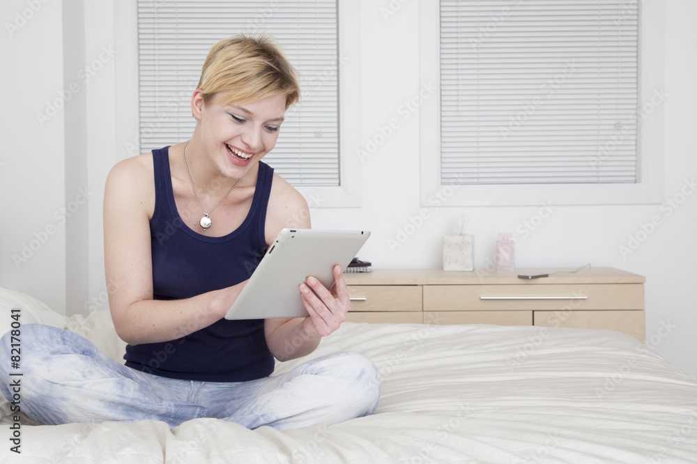 Caucasian woman using tablet computer on bed Caucasian woman using tablet computer on bed