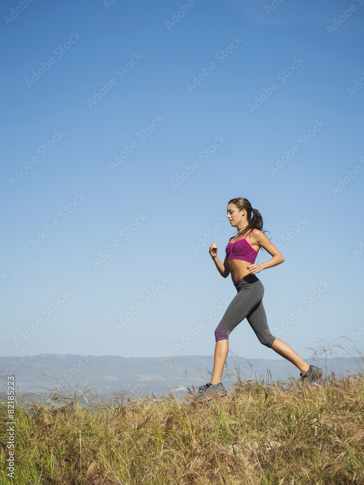 Mixed race woman running in rural landscape Mixed race woman running in rural landscape