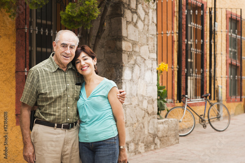 Hispanic couple smiling on city street photo