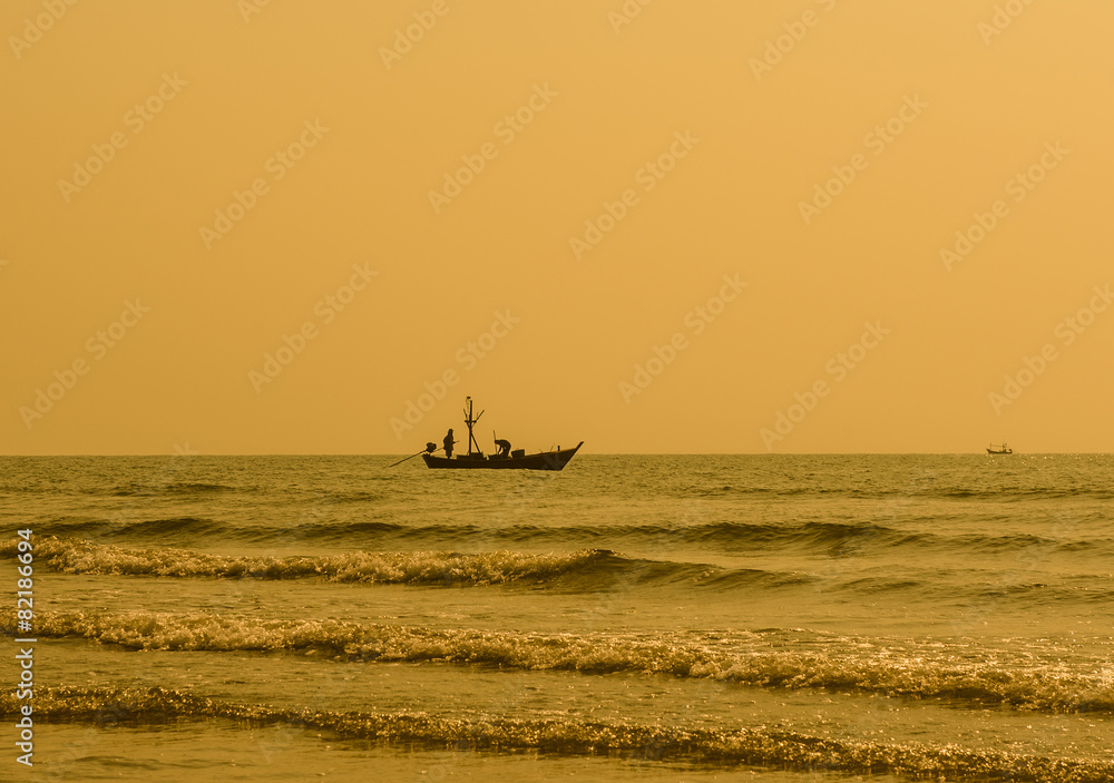 Fototapeta premium Silhouette of fisherman working on the boat. hua hin , Thailand.