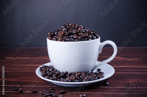 roasted coffee beans in coffee cup on wooden background