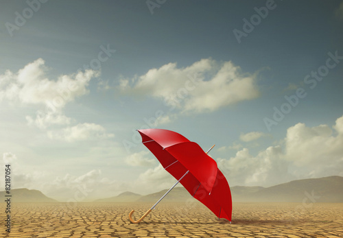 Red umbrella in desert landscape photo