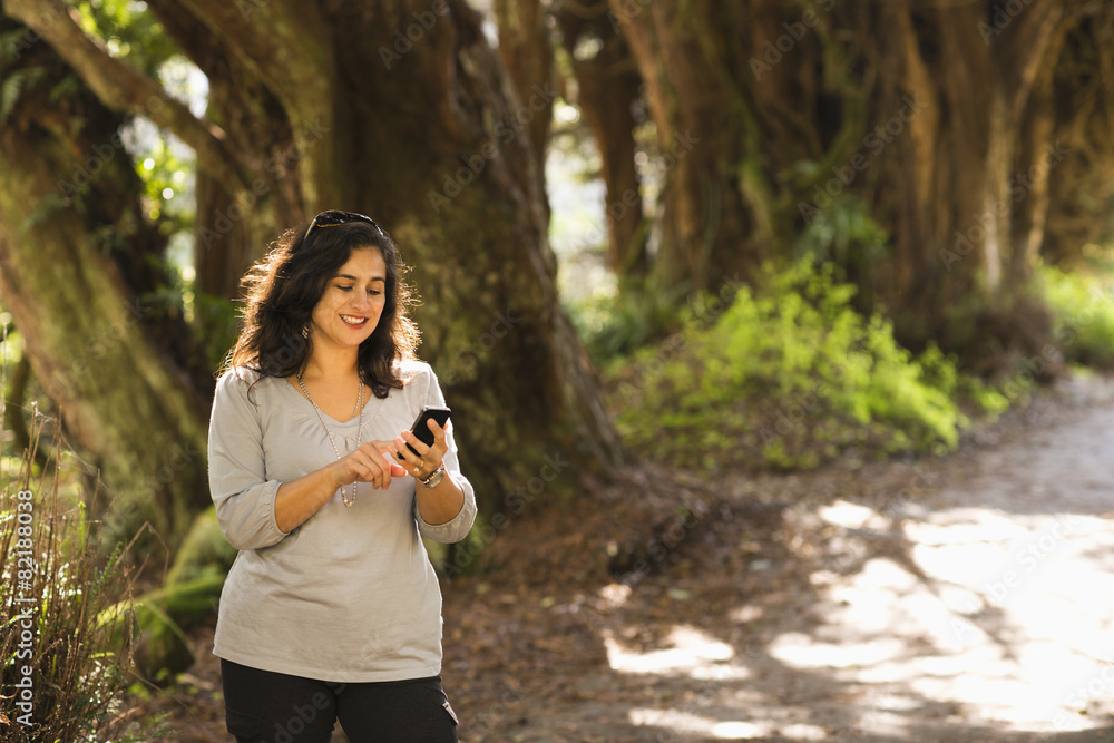 Hispanic woman using cell phone outdoors Hispanic woman using cell phone outdoors