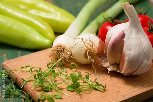 Garlic bud and spring onion on chopping bard with cress