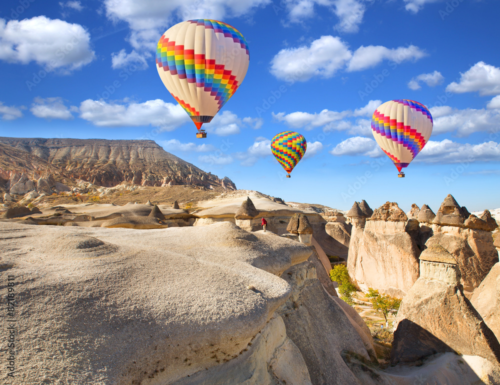 Hot air balloon flying over rock landscape at Cappadocia Turkey. - obrazy, fototapety, plakaty 
