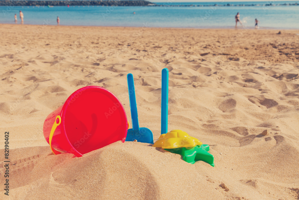 beach toys in sand on sea shore beach toys in sand on sea shore