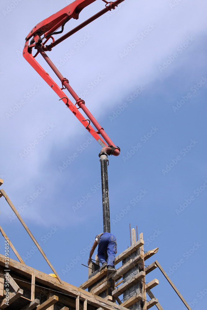 Builder worker with tube from truck mounted concrete pump Builder worker with tube from truck mounted concrete pump