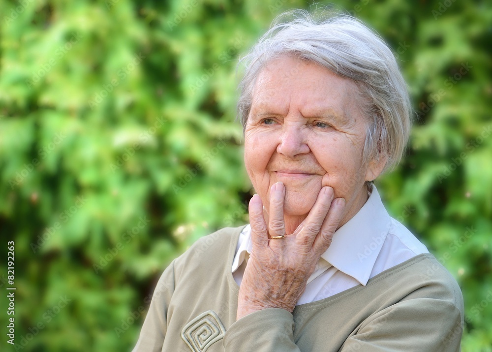 Senior woman smiling and dreaming in garden. Senior woman smiling and dreaming in garden.