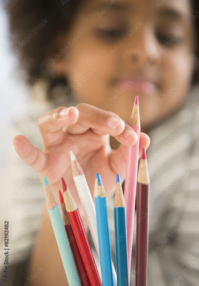 African American girl picking out colored pencil African American girl picking out colored pencil