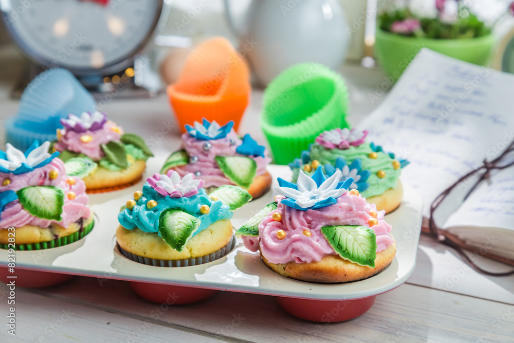 Decorating fresh muffins with cream and decoration