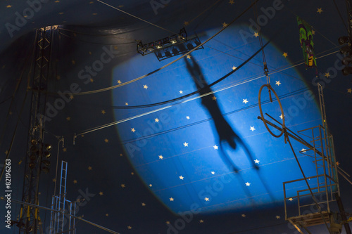 Shadow of acrobat in spotlight on wall
