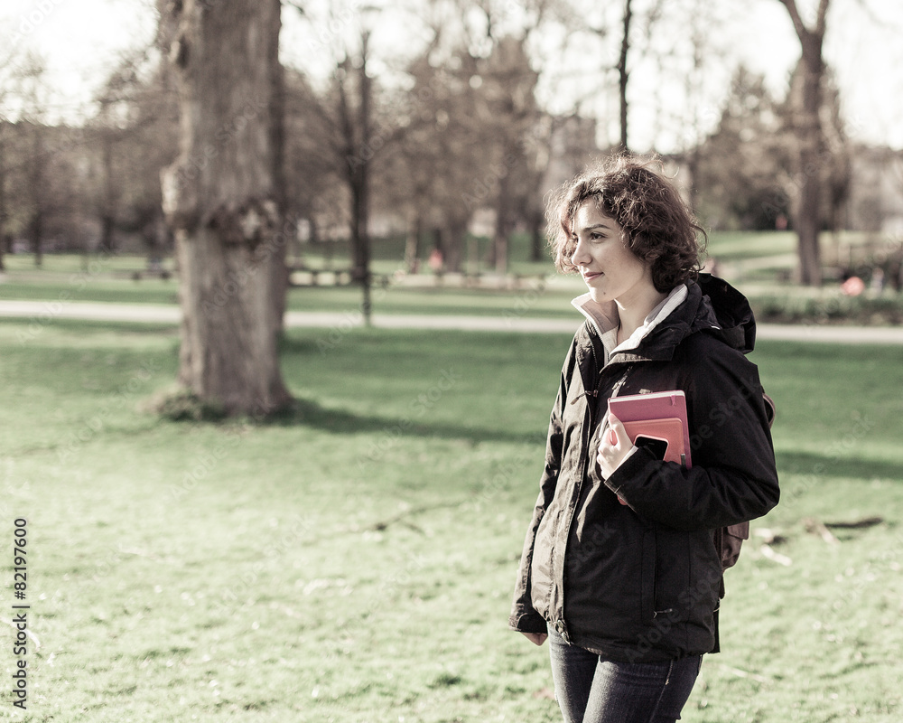 Young student holding books and walking around campus Young student holding books and walking around campus