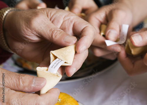 Asian family opening fortune cookies photo