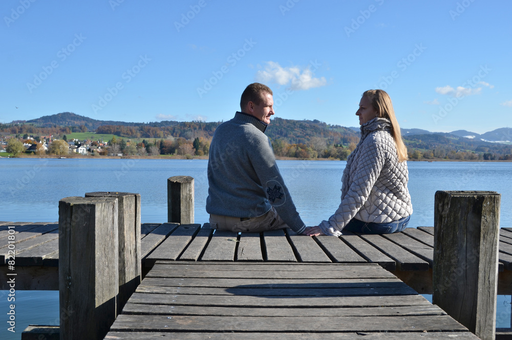 A couple on the wooden jetty at a lake. Switzerland