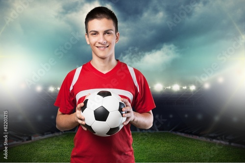 Soccer. Young soccer player with ball in front of white